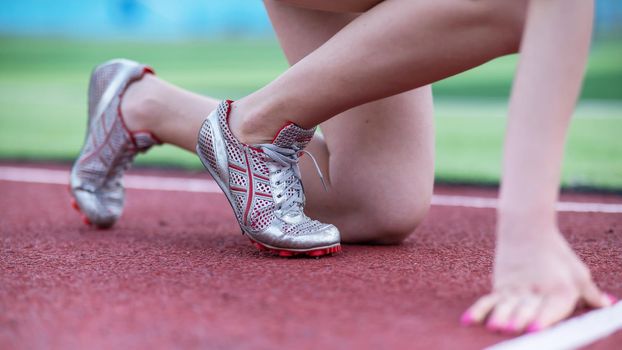 Close-up of female legs. The runner in the stadium is ready for the race