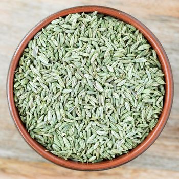 Fennel Seeds in bowl on wooden surface