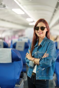 Portrait of an Asian woman taking a selfie or capturing memories while waiting for an economy class flight. Travel concept, vacations, tourism.