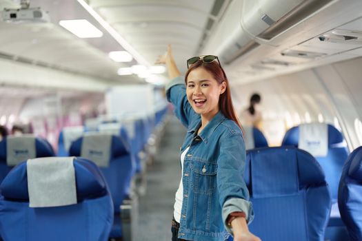 Portrait of an Asian woman taking a selfie or capturing memories while waiting for an economy class flight. Travel concept, vacations, tourism.