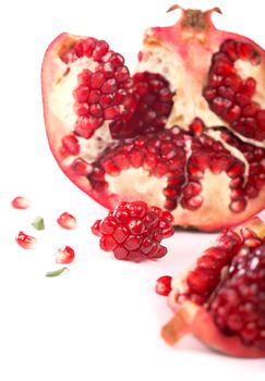 Juicy pomegranate and its half with leaves. Isolated on a white.