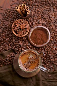 Hot black coffee and coffee beans on the old wooden