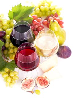 glasses of red and white wine and ripe grapes on table