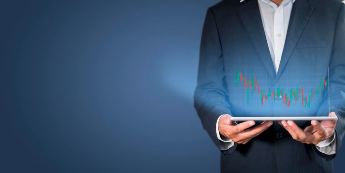 Hand of businessman holding tablet analysis stock market graph growth and increase of chart positive indicators. Hand holding tablet show stock chart on light gray background. copy space banner