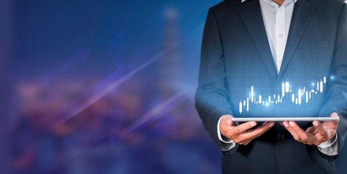 Hand of businessman holding tablet analysis stock market graph growth and increase of chart positive indicators. Hand holding tablet show stock chart on light gray background. copy space banner