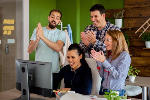 Corporate coworkers being happy of a big sale. Working in cozy start-up office