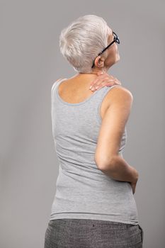 Neck and shoulder pain, senior old woman with short gray hair and body and spinal muscle problems