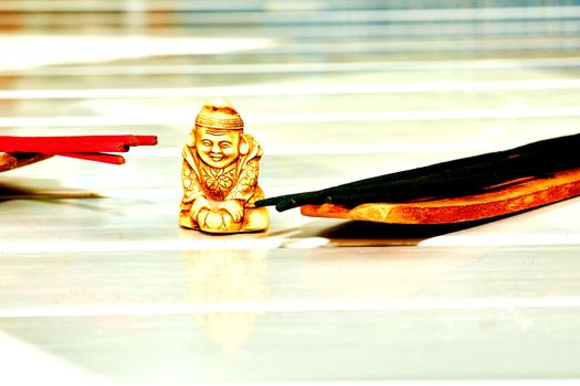 Think deeply or focus ones mind for a period of time, in silence, for religious or spiritual purposes or as a method of relaxation.Statuette of a Buddhist monk among incense