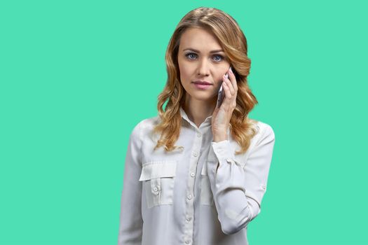 Young confident business woman in white blouse talking on mobile phone. Portrait of pretty woman talks on cell phone on color background.