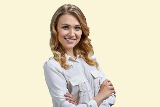 Pretty smiling woman in white blouse looking at camera with crossed arms. Beautiful young woman isolated on white background.