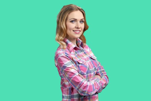 Beautiful smiling woman looking at camera with crossed arms. Friendly caucasian girl on color background.