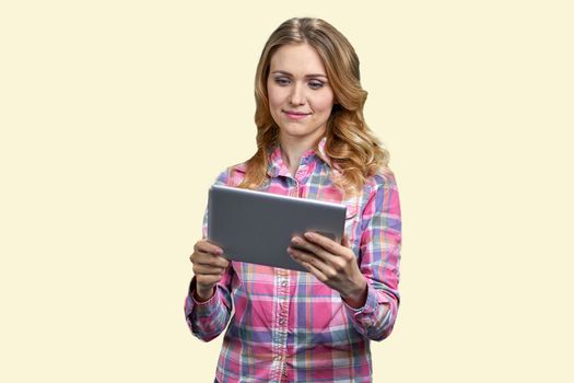 Young smiling woman looking at tablet pc. Isolated on white background. Pretty girl having video call.