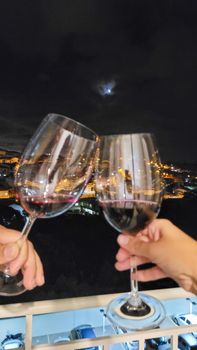 image of couple making a toast with glasses of wine in an apartment in Brazil