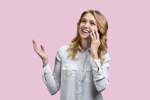 Surprised excited young business woman talking on cell phone against color background. People, technology and emotions concept.