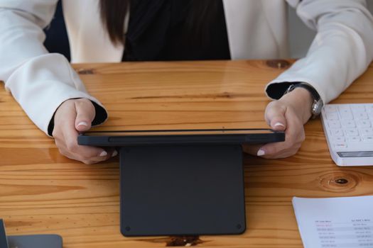 Portrait of a business woman using a tablet computer for data analysis, marketing, accounting.