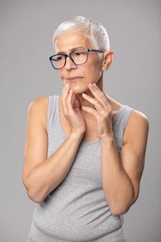 Toothache. pain tooth in mouth, old woman with worried expression, short gray hair and tootache problems, healthcare and medicine concept