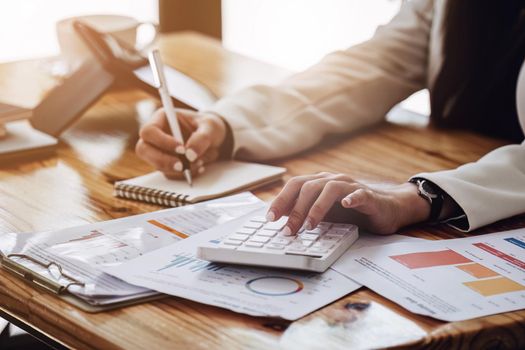 businss woman using calculator to calculating a sales and profit accounts on the report.