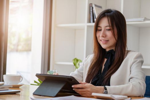 Portrait of a business woman using a tablet computer for data analysis, marketing, accounting.