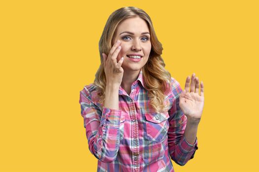 Pretty young woman touching her face with fingers on color background. Healthy skin concept.