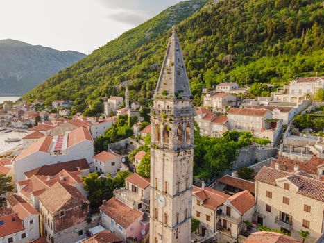 Scenic panorama view of the historic town of Perast at famous Bay of Kotor with blooming flowers on a beautiful sunny day with blue sky and clouds in summer, Montenegro, southern Europe.