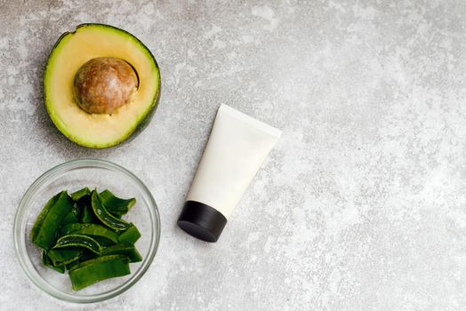 Moisturizing cream with aloe extract and avocado with a mockup on a gray background