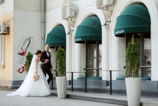 bride and groom near the cafe on the street of the summer city