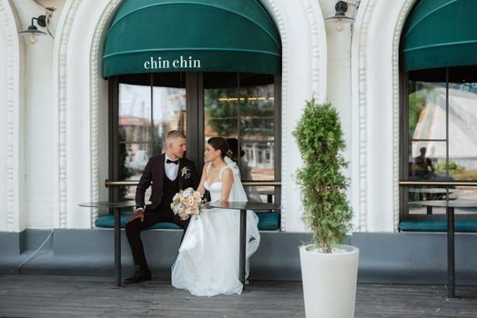 bride and groom near the cafe on the street of the summer city