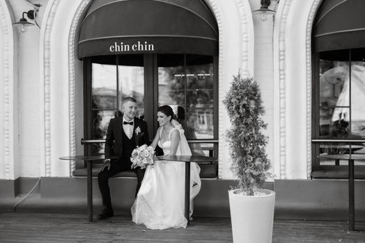 bride and groom near the cafe on the street of the summer city