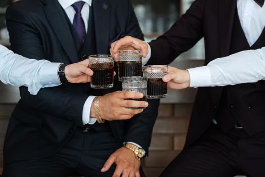 groom in a brown suit and his friends at the bar