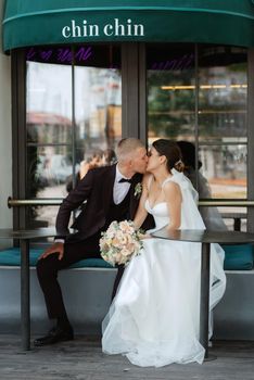 bride and groom near the cafe on the street of the summer city