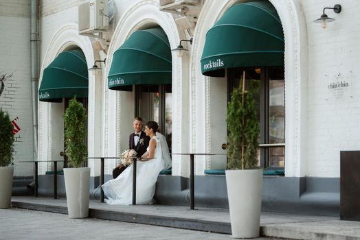 bride and groom near the cafe on the street of the summer city