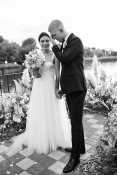 wedding ceremony on a high pier near the river with invited guests