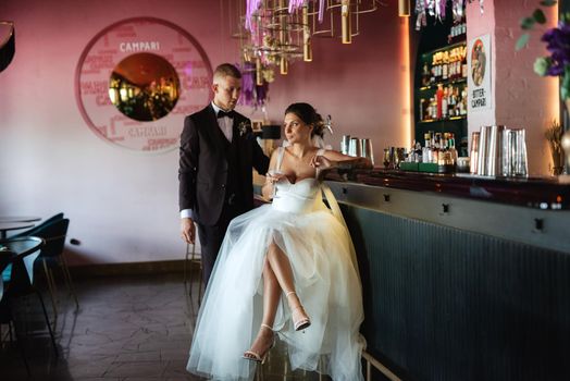 bride and groom inside a cocktail bar in a vibrant atmosphere