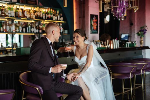 bride and groom inside a cocktail bar in a vibrant atmosphere