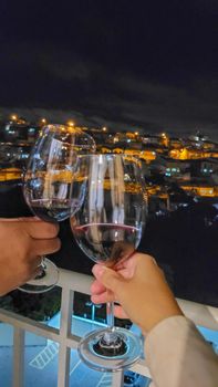 image of couple making a toast with glasses of wine in an apartment in Brazil