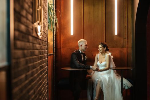 bride and groom inside a cocktail bar in a vibrant atmosphere