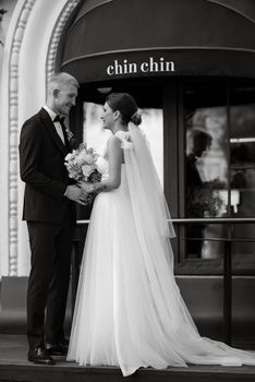 bride and groom near the cafe on the street of the summer city