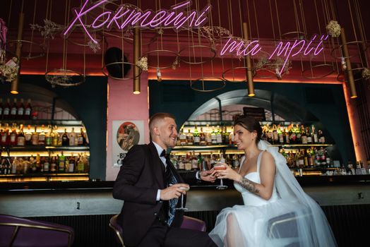 bride and groom inside a cocktail bar in a vibrant atmosphere