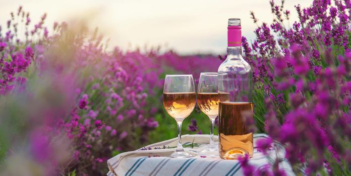 Wine in a lavender field. Selective focus. Food.