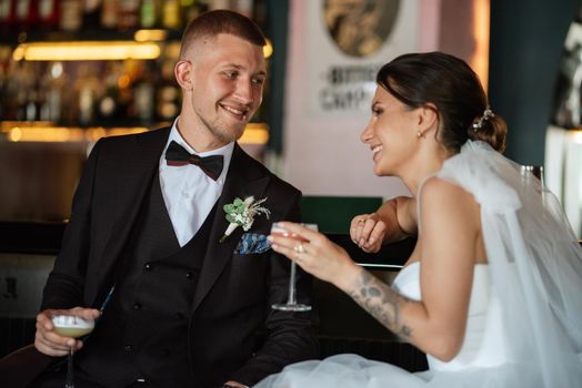 bride and groom inside a cocktail bar in a vibrant atmosphere