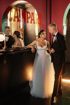 bride and groom inside a cocktail bar in a vibrant atmosphere