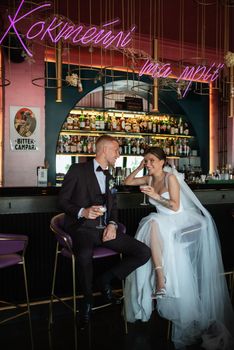 bride and groom inside a cocktail bar in a vibrant atmosphere