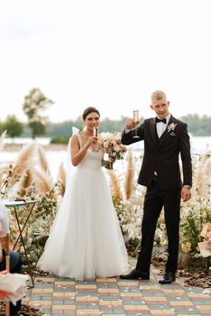 wedding ceremony on a high pier near the river with invited guests