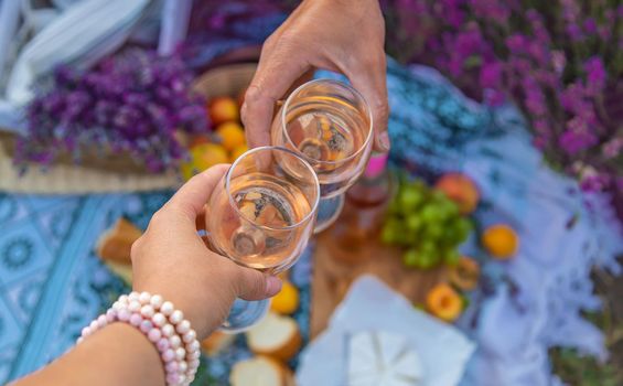 A woman and a man drink wine in a lavender field. Selective focus. Food.