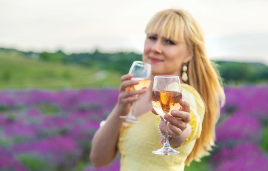 A woman drinks wine in a lavender field. Selective focus. Food.