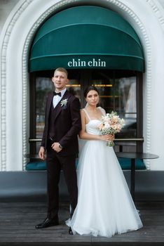 bride and groom near the cafe on the street of the summer city