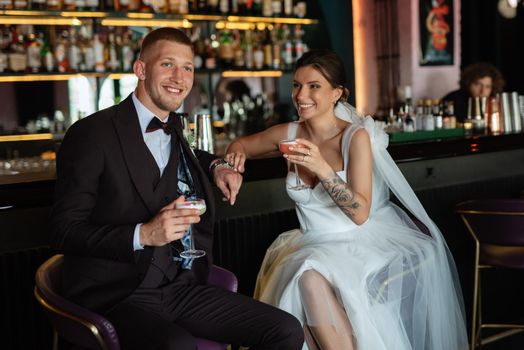 bride and groom inside a cocktail bar in a vibrant atmosphere