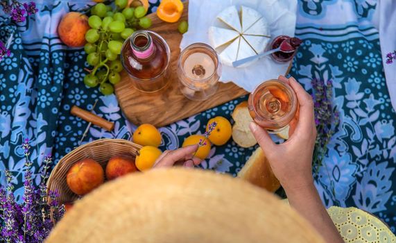 A woman drinks wine in a lavender field. Selective focus. Food.