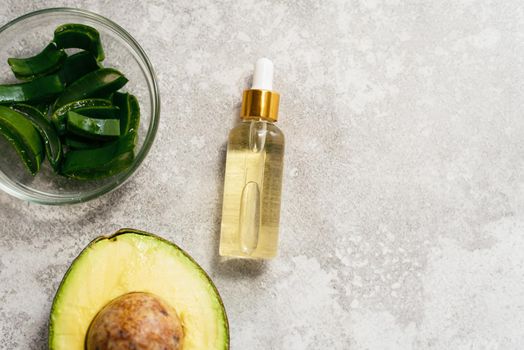 Aloe and avocado oil on a gray background. Natural extract oil