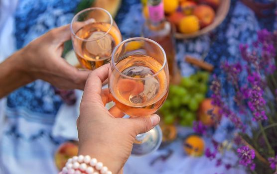 A woman and a man drink wine in a lavender field. Selective focus. Food.